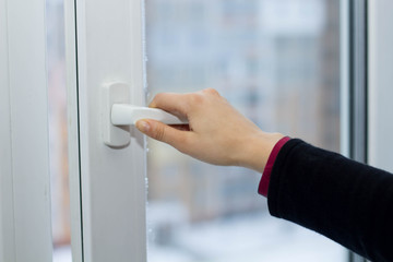 A woman are opening the window with one hand