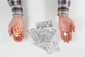 Obraz premium man hand with pill on the background of pills