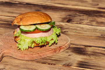 Fresh delicious homemade burger on wooden table