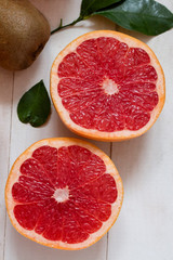 two halves of cut ripe juicy red grapefruit with on the table from above