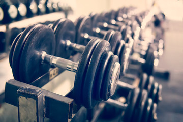 Rows of dumbbells in the gym with hign contrast and monochrome color tone