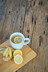 Fototapeta na wymiar Cup of ginger tea with lemon on wooden