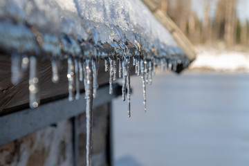 some icicles hanging at the gutter under the roof in winter