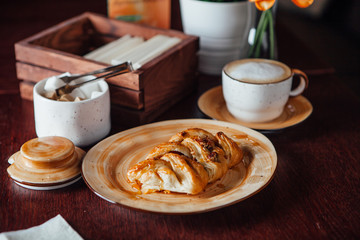 Freshly baked pecans on a plate of warm colors on a dark wood table