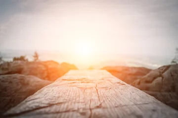 Tuinposter Wooden plank in front of the nature during the sunset.  Table background and spring time © Yura Yarema
