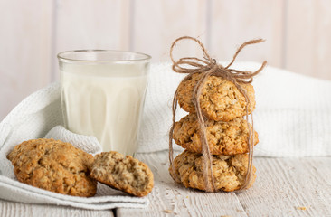 Oatmeal cookies with milk on tray on rustic wooden table