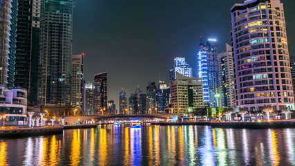 Fototapeta premium View of Dubai Marina Towers and canal in Dubai night timelapse
