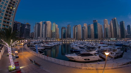 Fototapeta premium Dubai Marina at Blue hour night to day timelapse with yachts