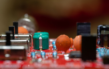Close up (Macro) of Printed Circuit Board PCB embedded components (inductors, resistors, capacitors, diodes, microchips, transistor) with short depth of view