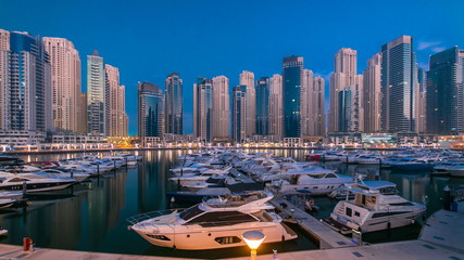 Obraz premium Dubai Marina at Blue hour night to day timelapse with yachts