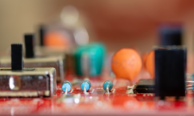 Close up (Macro) of Printed Circuit Board PCB embedded components (inductors, resistors, capacitors, diodes, microchips, transistor) with short depth of view