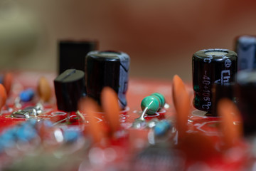Close up (Macro) of Printed Circuit Board PCB embedded components (inductors, resistors, capacitors, diodes, microchips, transistor) with short depth of view