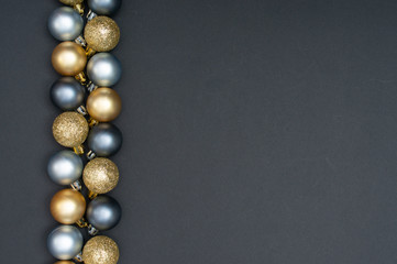 Multiple Christmas silver and gold baubles creative decoration pattern with the black background and copy space at the right
