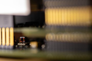 Close up (Macro) of Printed Circuit Board PCB embedded components (inductors, resistors, capacitors, diodes, microchips, transistor) with short depth of view.