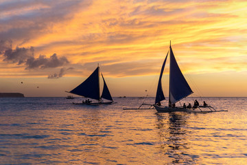 Fototapeta na wymiar Small sailing boats at the sunset. Boracay, Philippines