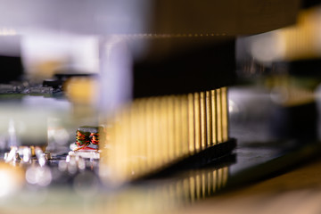 Close up (Macro) of Printed Circuit Board PCB embedded components (inductors, resistors, capacitors, diodes, microchips, transistor) with short depth of view.