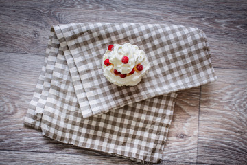 Close-up shot with whipped cream, fresh berries on a light checkered linen napkin.