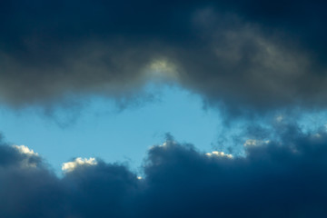 Fototapeta na wymiar Blue sky between dark clouds copy space background
