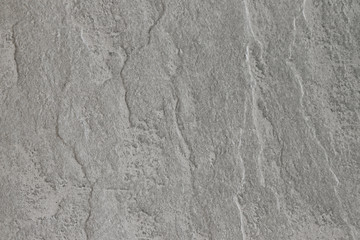 The texture of a dark gray stone with a rough and matte surface. Grunge background with space for text or image. Grey backdrop.