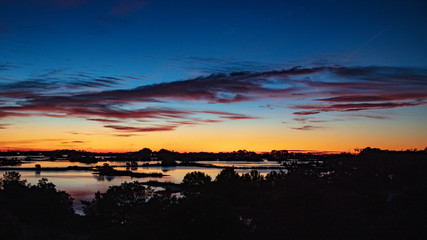Dramatic blue, orange, red and yellows fill the winter morning sky over a Gulf of Mexico bayou in Florida's Nature Coast community