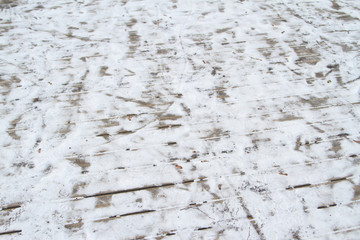 Old wood pattern path with white snow on it.