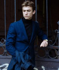 Portrait of confident young business man looking at camera with happy facial expression outdoors. Successful attractive caucasian man posing on the street and smiling