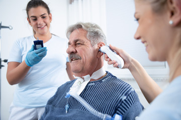 Two nurses care for an intensely awake patient in the hospital nursing home