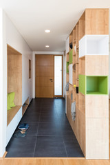 Fototapeta na wymiar Custom made colorful wooden shelves in the hall of modern house