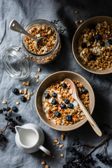 Homemade peanut butter granola with greek yogurt and blueberries on a grey background, top view. Healthy energy breakfast or snack. Flat lay