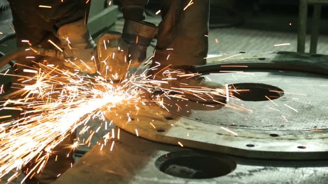 Worker at a factory working with a grinding machine