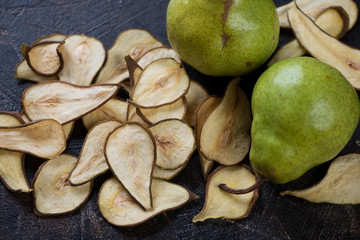 Closeup of crispy fruit chips made of pear and ripe pears, studio shot