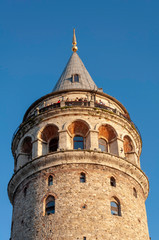 Galata Tower, which is a famous place in Istanbul, is a beautiful day with tourists.