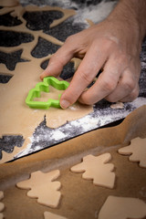 Cooking cookies with cookie cutters on a dark table 
