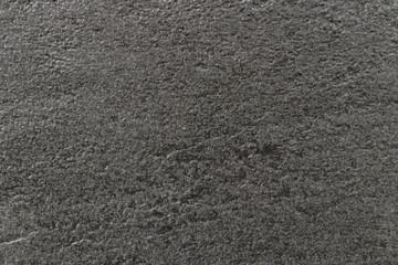 Fototapeta premium The texture of a dark gray stone with a rough and matte surface. Grunge background with space for text or image. Empty template and mockup for designers.