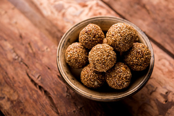 Tilgul Laddu or Til Gul balls for makar sankranti, it's a healthy food made using sesame, crushed peanuts and jaggery. served in a bowl. selective focus showing details.