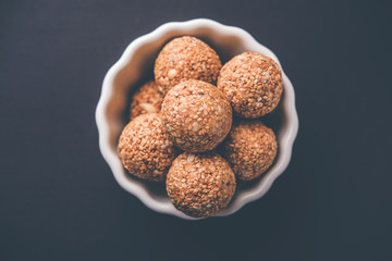 Tilgul Laddu or Til Gul balls for makar sankranti, it's a healthy food made using sesame, crushed peanuts and jaggery. served in a bowl. selective focus showing details.