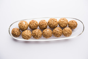 Tilgul Laddu or Til Gul balls for makar sankranti, it's a healthy food made using sesame, crushed peanuts and jaggery. served in a bowl. selective focus showing details.