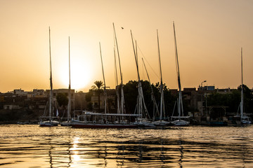 sunset Nile Aswan the West Bank with small village houses with fishing sailing boats felucca