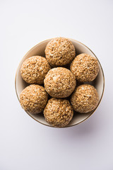 Tilgul Laddu or Til Gul balls for makar sankranti, it's a healthy food made using sesame, crushed peanuts and jaggery. served in a bowl. selective focus showing details.