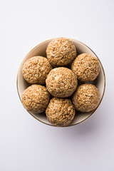 Tilgul Laddu or Til Gul balls for makar sankranti, it's a healthy food made using sesame, crushed peanuts and jaggery. served in a bowl. selective focus showing details.