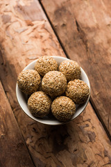 Tilgul Laddu or Til Gul balls for makar sankranti, it's a healthy food made using sesame, crushed peanuts and jaggery. served in a bowl. selective focus showing details.