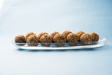 Tilgul Laddu or Til Gul balls for makar sankranti, it's a healthy food made using sesame, crushed peanuts and jaggery. served in a bowl. selective focus showing details.