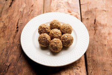 Tilgul Laddu or Til Gul balls for makar sankranti, it's a healthy food made using sesame, crushed peanuts and jaggery. served in a bowl. selective focus showing details.