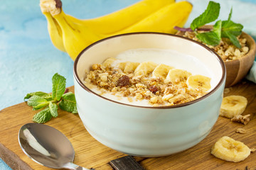 Granola. Granola with yogurt, chocolate and banana on blue concrete or stone table. The concept of healthy nutrition and diet.