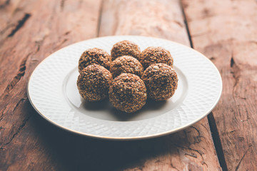 Tilgul Laddu or Til Gul balls for makar sankranti, it's a healthy food made using sesame, crushed peanuts and jaggery. served in a bowl. selective focus showing details.