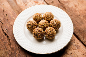 Tilgul Laddu or Til Gul balls for makar sankranti, it's a healthy food made using sesame, crushed peanuts and jaggery. served in a bowl. selective focus showing details.