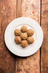 Tilgul Laddu or Til Gul balls for makar sankranti, it's a healthy food made using sesame, crushed peanuts and jaggery. served in a bowl. selective focus showing details.