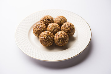 Tilgul Laddu or Til Gul balls for makar sankranti, it's a healthy food made using sesame, crushed peanuts and jaggery. served in a bowl. selective focus showing details.