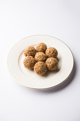 Tilgul Laddu or Til Gul balls for makar sankranti, it's a healthy food made using sesame, crushed peanuts and jaggery. served in a bowl. selective focus showing details.