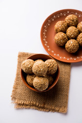 Tilgul Laddu or Til Gul balls for makar sankranti, it's a healthy food made using sesame, crushed peanuts and jaggery. served in a bowl. selective focus showing details.